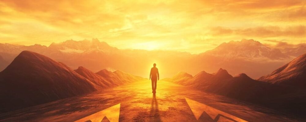 Confident person looking toward sunrise representing future built with abundance mindset